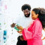 Home Two adults exploring medicine options at a pharmacy in Lagos, Nigeria.